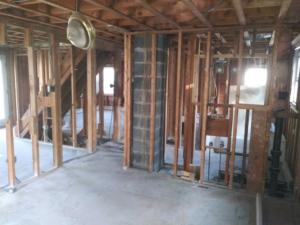 A staircase under construction or renovation, showing exposed framing and partially painted steps by J-BO Enterprises, Inc in Wilmington, MA.