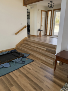 A completed staircase and entryway flooring and handrail installation project by M Squared Construction LLC in Tonganoxie, KS.