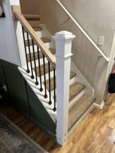 A renovated staircase with a newel post and railing installed by Premier Handyman Services in Lexington, KY.