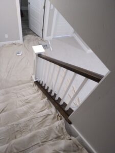 A staircase covered with drop cloths, prepared for painting or finishing by Eagle Rock Handyman Services in Caldwell, ID.