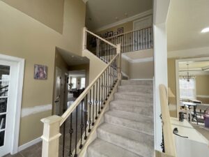 A renovated interior staircase featuring new wooden handrails and black metal balusters by Inspired Renovation & Hardscape's in Lorain, OH.
