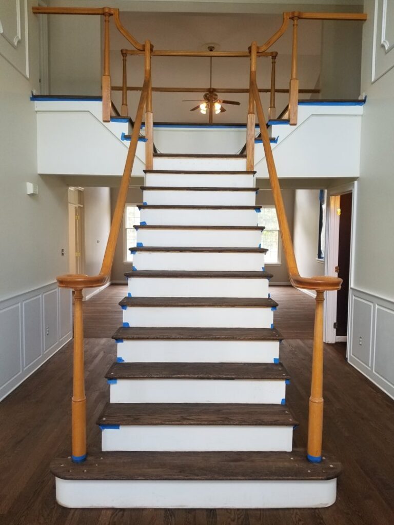 Staircase renovation with dark treads, white risers, and painter's tape by Just Floor It Hardwood Floors LLC in Philadelphia, PA