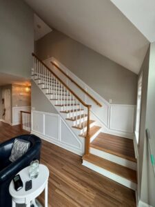 A renovated living area featuring a new staircase and wainscoting installation by Quinonez Painting & Renovations LLC in Providence, RI.