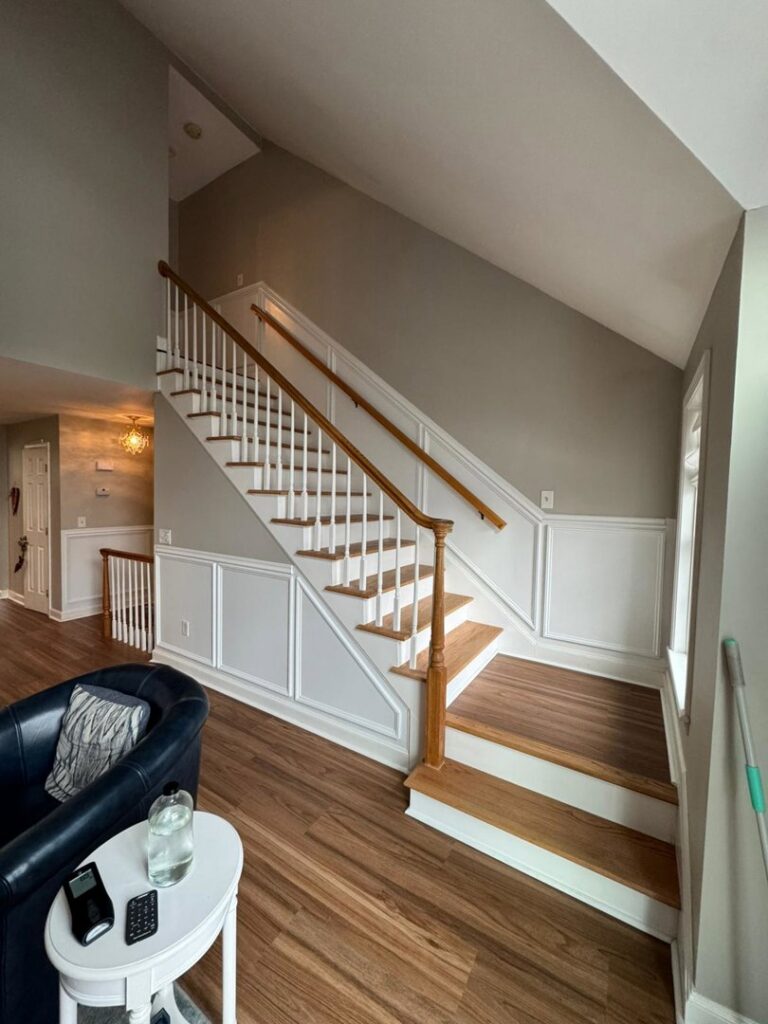 A renovated living area featuring a new staircase and wainscoting installation by Quinonez Painting & Renovations LLC in Providence, RI.
