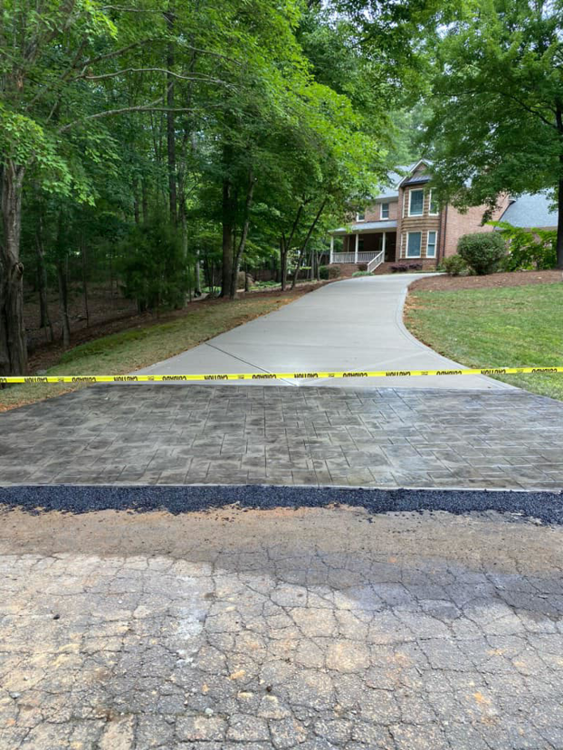 A newly installed stamped concrete driveway section by Titan Built Construction, LLC, offering handyman services in Huntersville, NC.