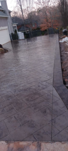 A newly installed stamped concrete driveway by Titan Built Construction, LLC, providing handyman services in Huntersville, NC.