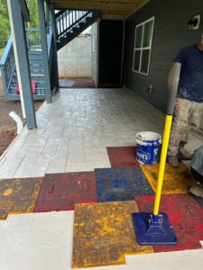 Stamped concrete patio installation in progress under a deck by Solid Rock Builders in Rock Hill, SC.