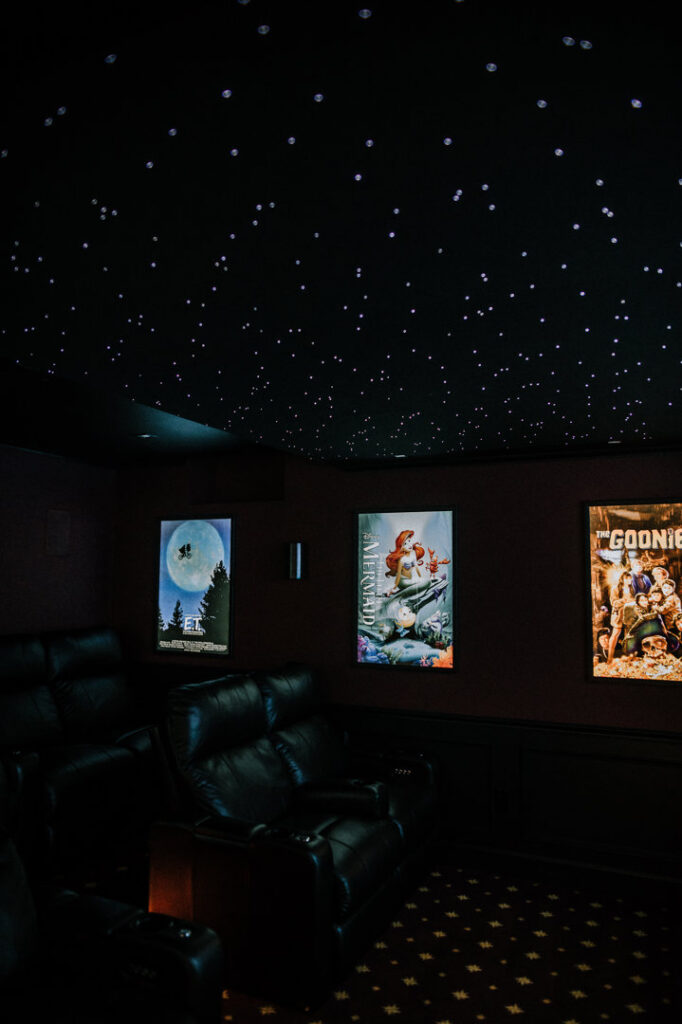 A custom home theater room featuring a unique starry ceiling and movie posters by Knaub Home Solutions in Rochester, NY.