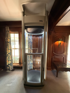 A Stiltz home lift expertly installed by Stiltz of Charlotte Raleigh Greenville in a wood-paneled room in Concord, NC.
