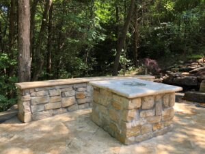 A custom stone fire pit and seating area built by Rescue Landscaping and Outdoor Living in St. Louis, MO