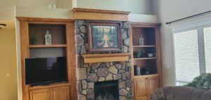 A beautifully finished stone fireplace with custom built-in shelves by Constructed by 360 LLC in Meridian, ID.