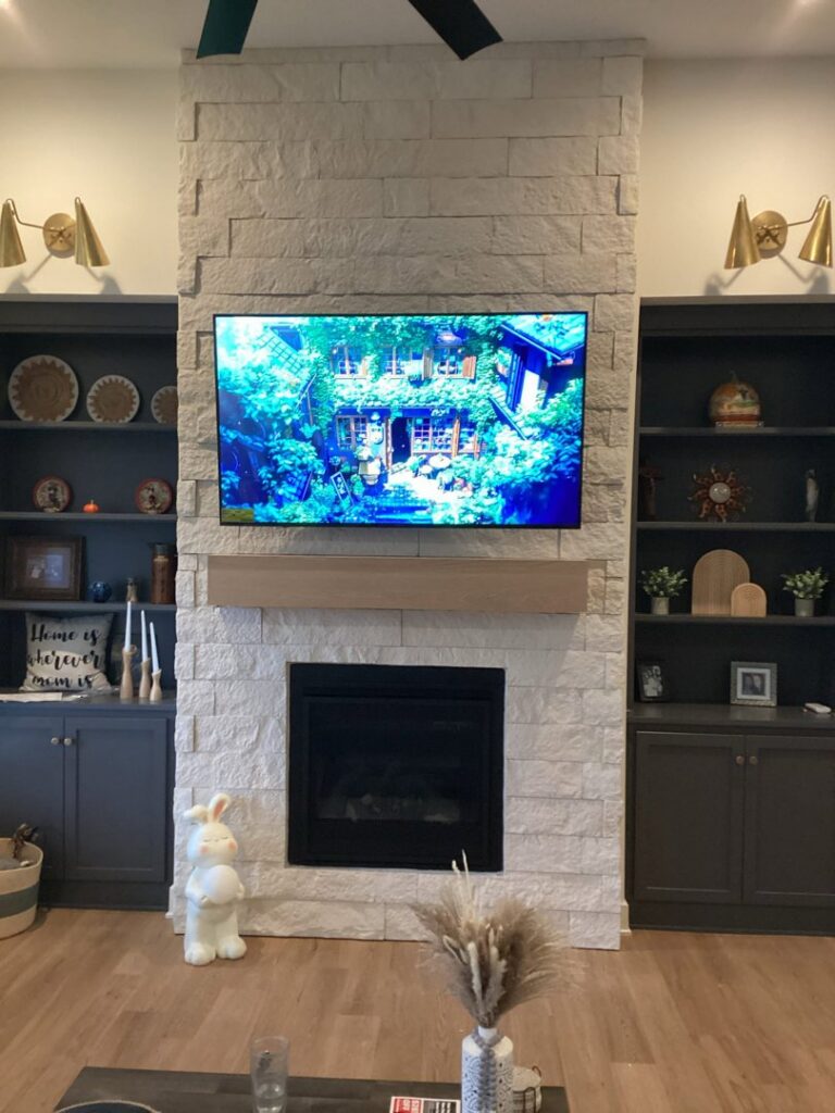 A modern living room with a newly installed stone fireplace and custom built-in shelves by Mr. Handyman of Olathe, Gardner in Olathe, KS.