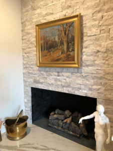 A beautifully installed stone veneer fireplace surround by Camelot Builders in Essex, CT.