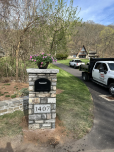 A stone mailbox pillar with house number 1407 installed by Tomori's masonry llc in Cheshire, CT