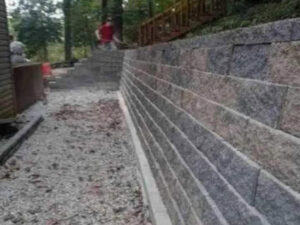 A newly constructed stone retaining wall, demonstrating outdoor improvement services by Huntington Home Repair in Huntington, WV.