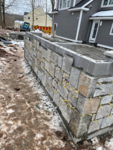 A stone retaining wall under construction by Tomori's masonry llc in Cheshire, CT