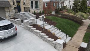 Custom stone retaining walls, concrete steps, and metal handrails installed by Rescue Landscaping and Outdoor Living in St. Louis, MO