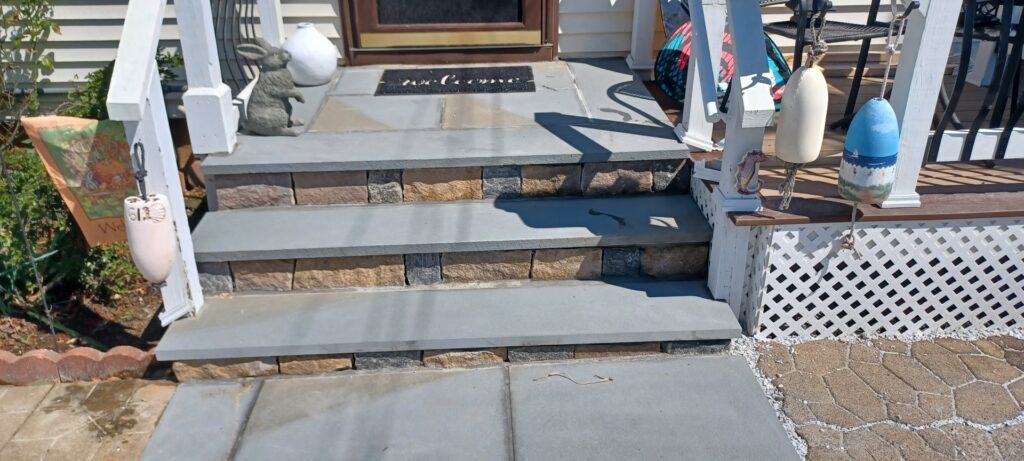Newly installed stone steps and a walkway leading to a home by Dynamic Design & Remodeling in Westport, CT