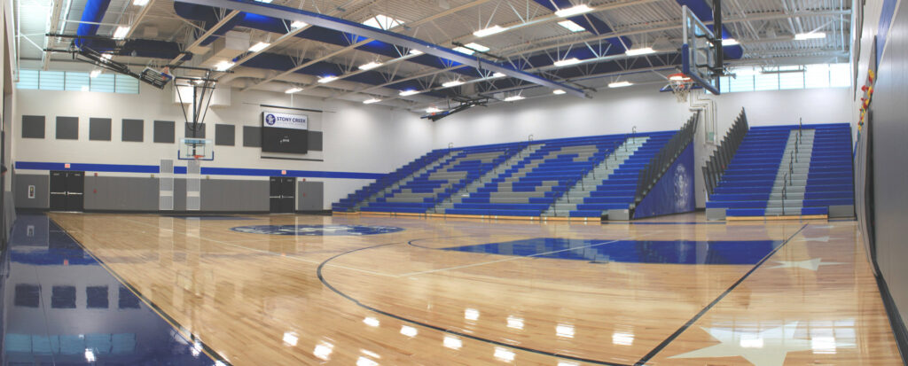 The interior of the completed Stony Creek Gymnasium, featuring a basketball court and bleachers, built by Frontier Construction, Inc. in Chicago, IL.