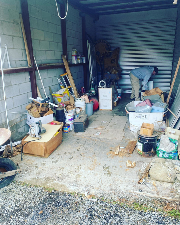 A cluttered storage unit being cleaned out by a trash_tiger team member, providing junk removal services in Canton, OH.