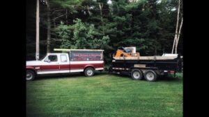 A truck and trailer at a storage unit filled with items, showing a cleanout service by Tiny's Trash & Hauling Service L.L.C in Williamstown, VT