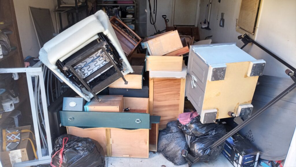 A storage unit completely filled with various junk items, including furniture and boxes, ready for HAULA Junk Removal in Canton, OH.