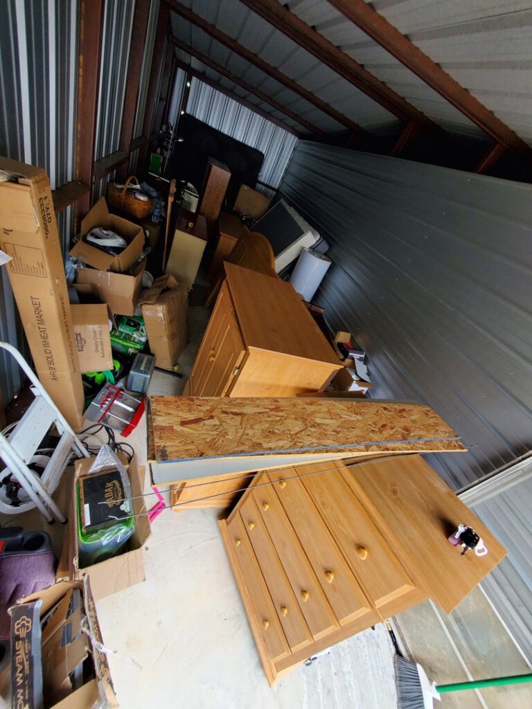 A storage unit packed with furniture and boxes, ready for a cleanout by Sonny Day Junk Removal in Batesville, AR.