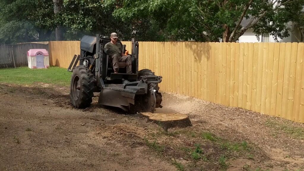 A crane truck removing a large tree that has fallen onto a house due to storm damage by Mr. Stump Tree Service in Colorado Springs, CO.