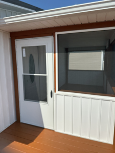A newly installed white storm door and screened porch section by ACC Construction in Knoxville, TN.