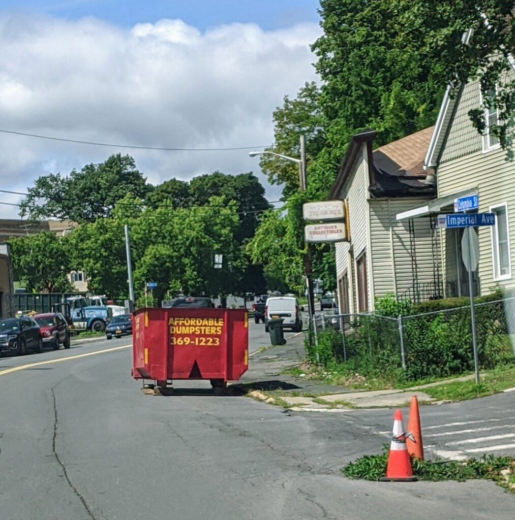 A red dumpster from Affordable Dumpsters placed street-side for junk removal in Watervliet, NY.