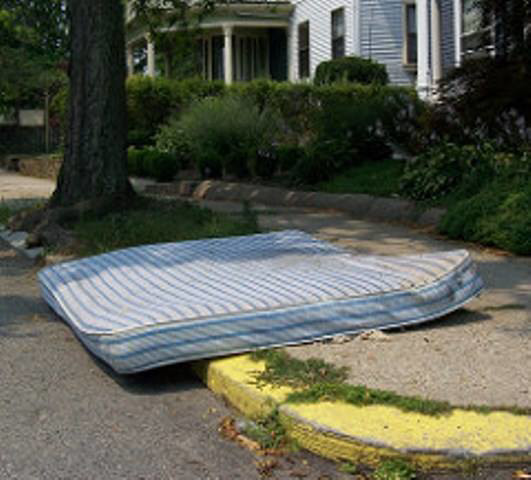 A striped mattress left on the curb for pickup by Omaha junk Removal and Hauling Service in Omaha, NE.
