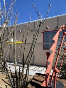 Stucco repair work in progress on a house exterior, showing materials and tools, by Old Pueblo Stucco, Inc. in Tucson, AZ