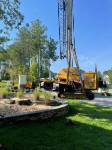 A Vermeer stump grinder being lifted by a crane at a job site by Tree service Rigoberto peraza in Atlanta, GA.
