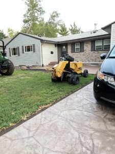 A professional stump grinder machine on a residential lawn, ready for stump removal by ArborMaster Tree Service Sioux Falls SD.