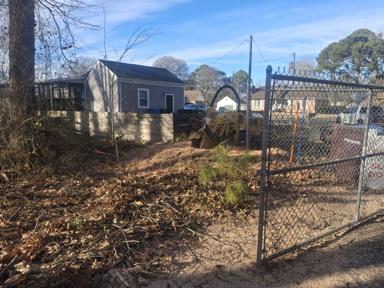 A stump grinder machine and a pile of wood chips after a job by Alley's Tree Service in Va Beach, VA.