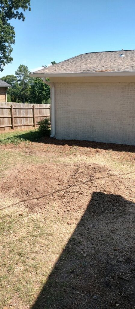 A cleared area of ground with wood chips, indicating recent stump grinding or tree removal by J & K Tree Service in Robbins, NC.