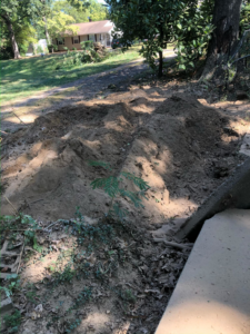 A pile of wood chips and soil, indicating recent stump grinding or tree removal by Skidmore's Tree Service in Winston-Salem, NC.