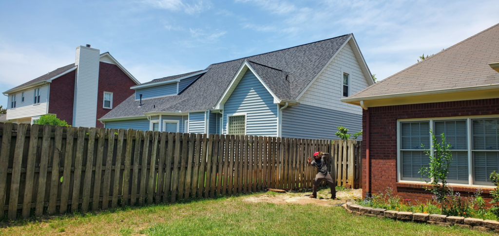 A professional performing stump grinding service in a residential backyard by Chris's Tree Service in Hazel Green, AL