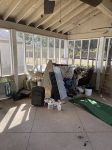 A sunroom overflowing with household clutter and old furniture, awaiting junk removal by G.I. HAUL Austin, TX.