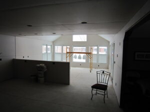A sunroom addition under construction with new drywall sheets ready for installation by Hibbard Home Improvement in Williamsville, NY.