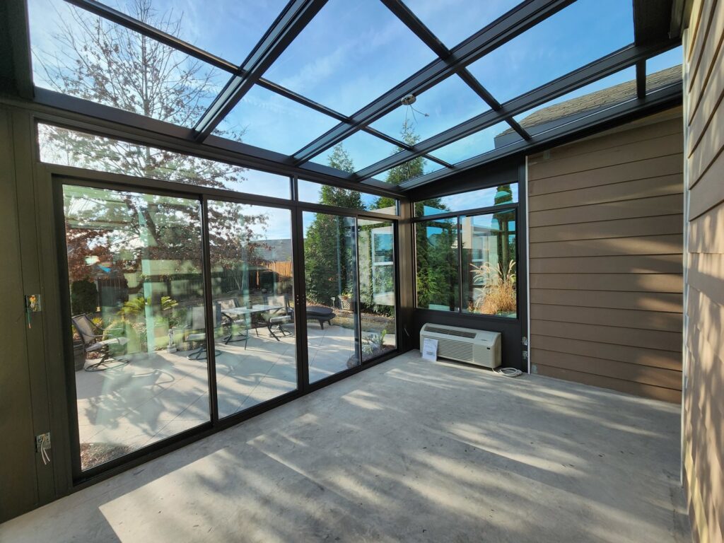 The interior of a sunroom with a glass roof and large windows by Four Seasons of River City in Columbus, GA.