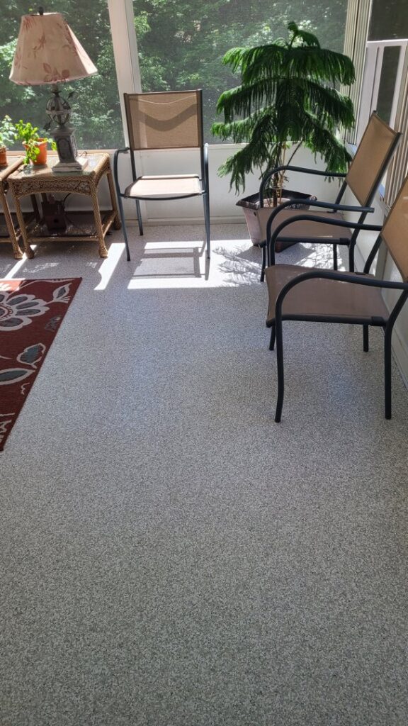 A bright sunroom or enclosed porch featuring a new, speckled floor coating by Egli Coating Solutions in Evansville, IN.