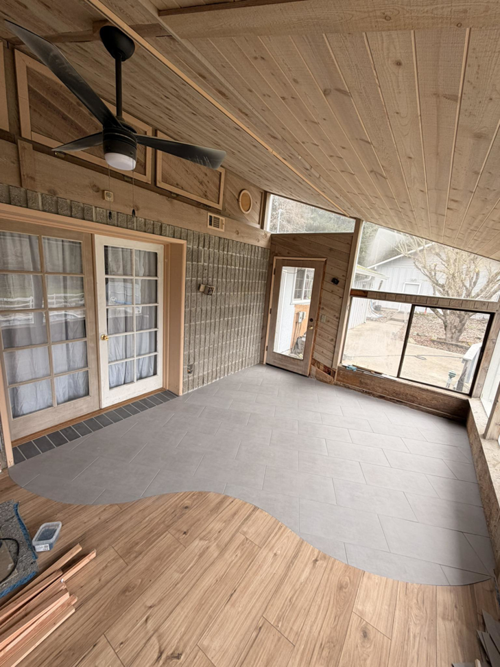 A sunroom with new tile flooring being installed, transitioning to wood, by Connolly Tile LLC in Medford, OR.