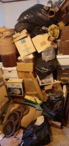 A tall pile of boxes, trash bags, and various items awaiting general junk removal by BumbleBee Junk in Sun Valley, CA