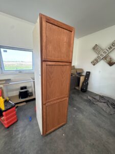 A tall wooden storage cabinet, likely for a pantry or garage, installed by Northeast SD Handyman in Watertown, SD.