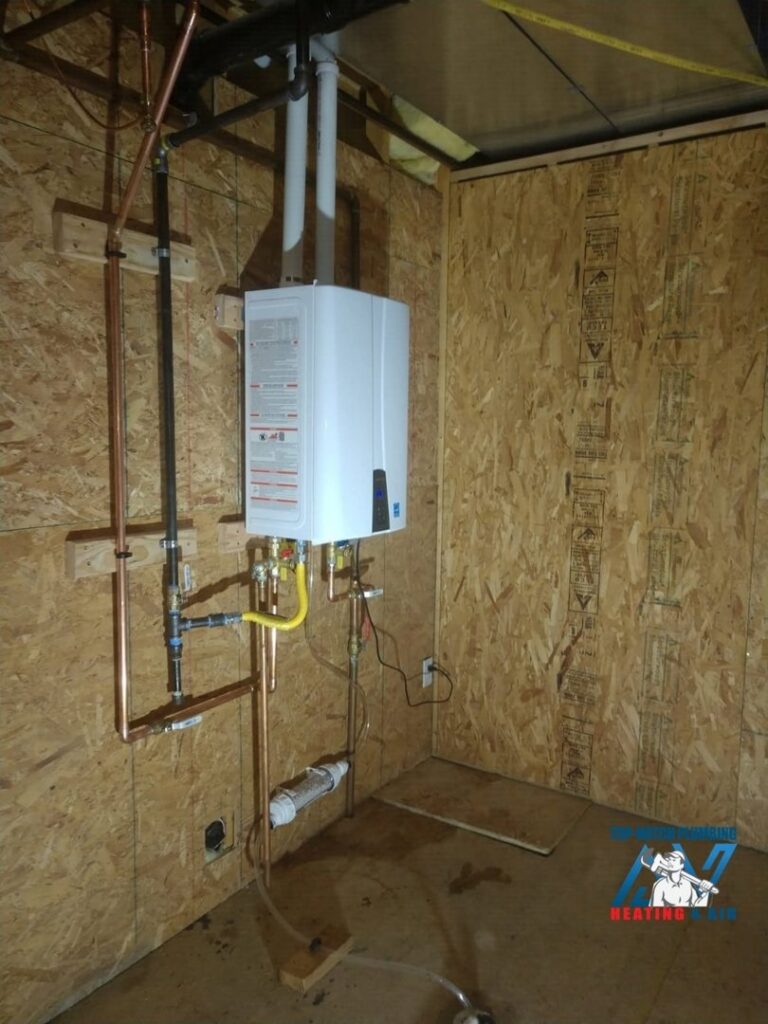 A newly installed tankless water heater with copper and PVC piping by Top-Notch Plumbing, Heating & Air in Greeley, CO.
