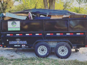 A tarped dump trailer filled with junk, displaying the D's Dumpster Rentals logo, in Overland Park, KS.