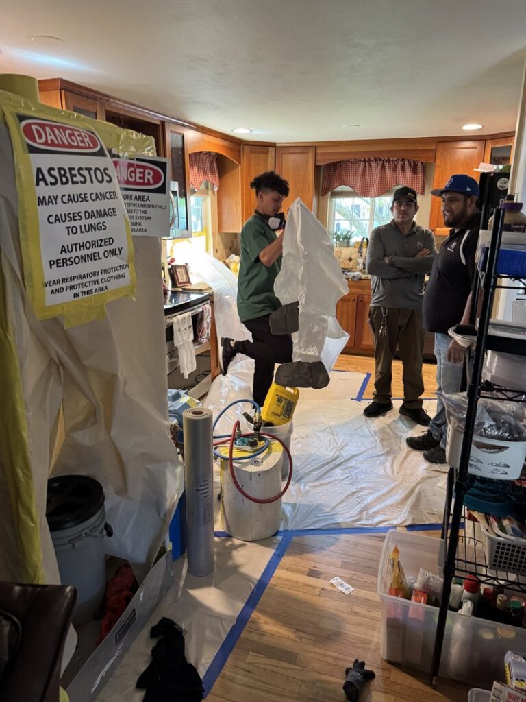 A team of workers preparing for asbestos abatement in a kitchen by Asbestos Abatement, Inc in Englewood, CO.