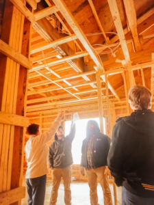 A team inspecting the wooden framing and electrical wiring of a barndominium project by Nashville Barndo Builders in Franklin, TN.