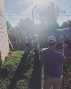 A team from Alva Roofing installing a new wooden fence in a backyard in Oklahoma City, OK.